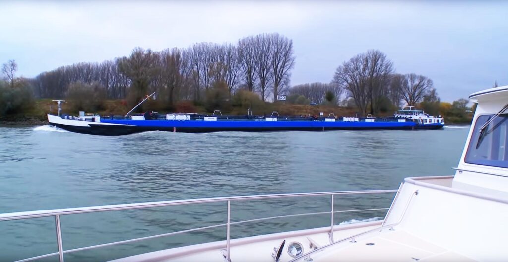 Venture II on Rhine with blue barge on river Rhine