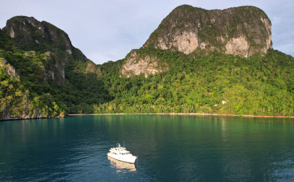 Fleming 85 anchored near mountains rising from ocean