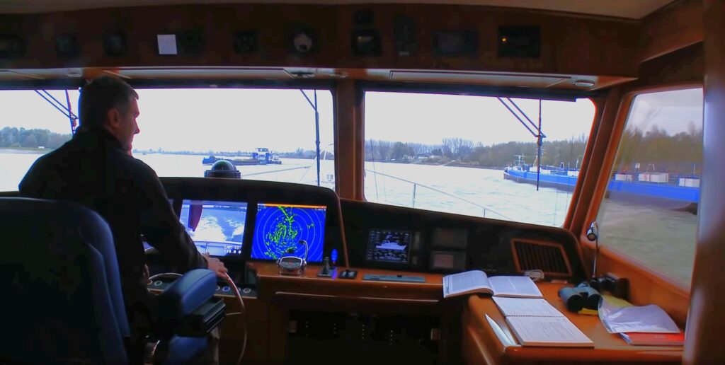 Simon Culling at helm of Venture II going up the Rhine to Düsseldorf.